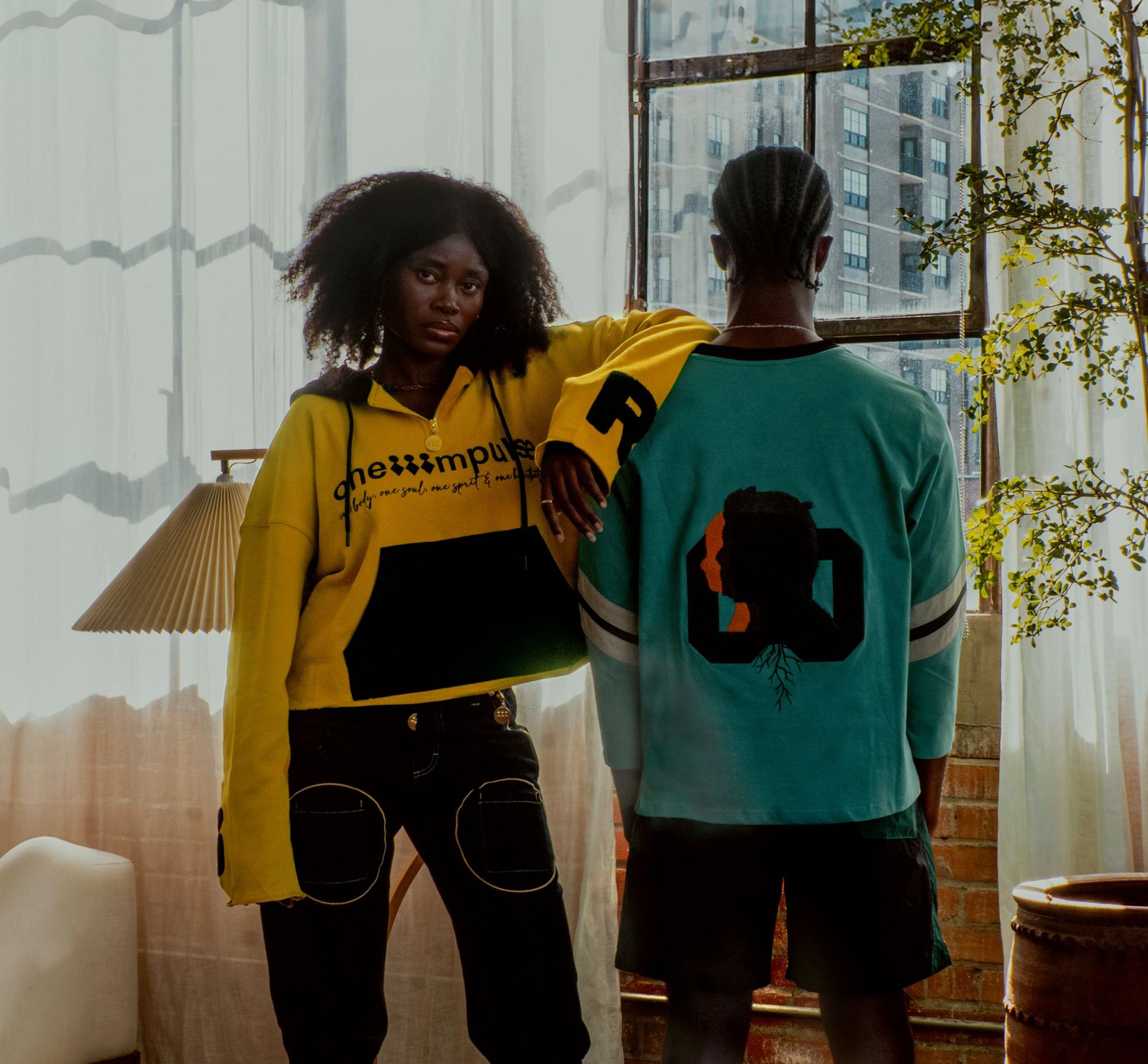 Two people wearing the hoodie and the two-tone jersey